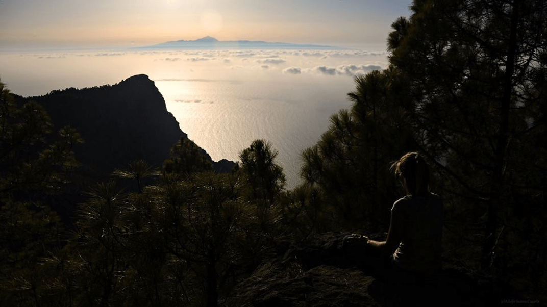 Foto paisajística sacada desde Gran Canaria, apuntando hacia Tenerife. Se puede apreciar un hermoso amanecer, las cordilleras volcánicas y el Teide de fondo